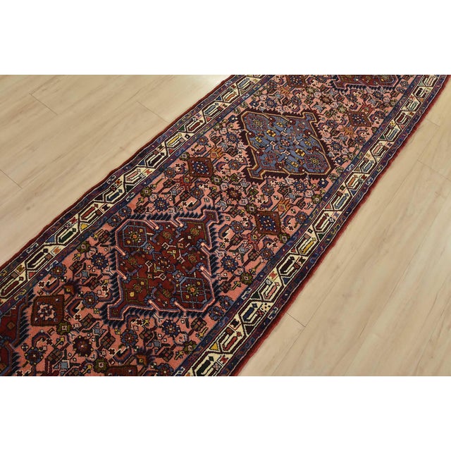 An authentic vintage tribal Hamedan runner hand-knotted with fine wool and natural dyes. This nomadic rug features a row...