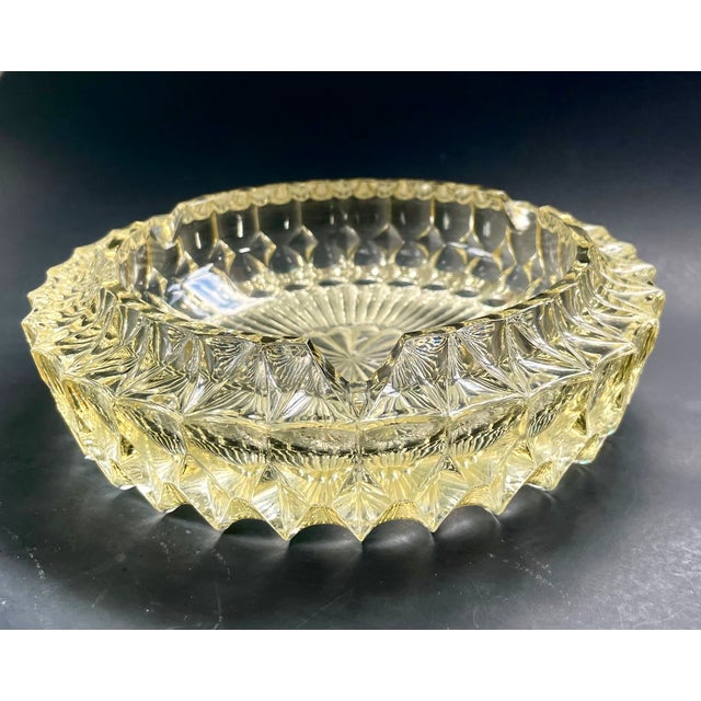 Beautiful vintage glass ashtray from the 1970s. This large, heavy lead glass piece has a soft yellow tint and features...