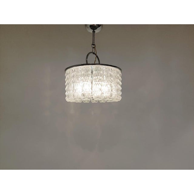 Mid century chandelier with linked glass lamp shades and chrome. The lamp emits a beautiful light. Good condition Works...