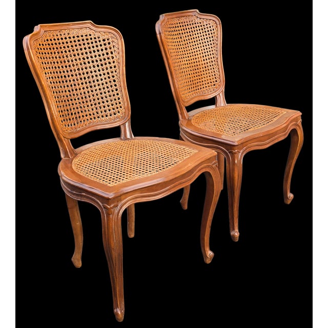 Elegant pair of Italian Louis XV style side chairs, crafted in walnut and retaining their original hand-woven cane seats...