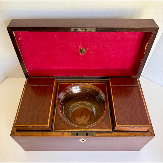 Dating to the mid-19th century, this handsome English mahogany tea caddy chest features two hinged tea compartments...