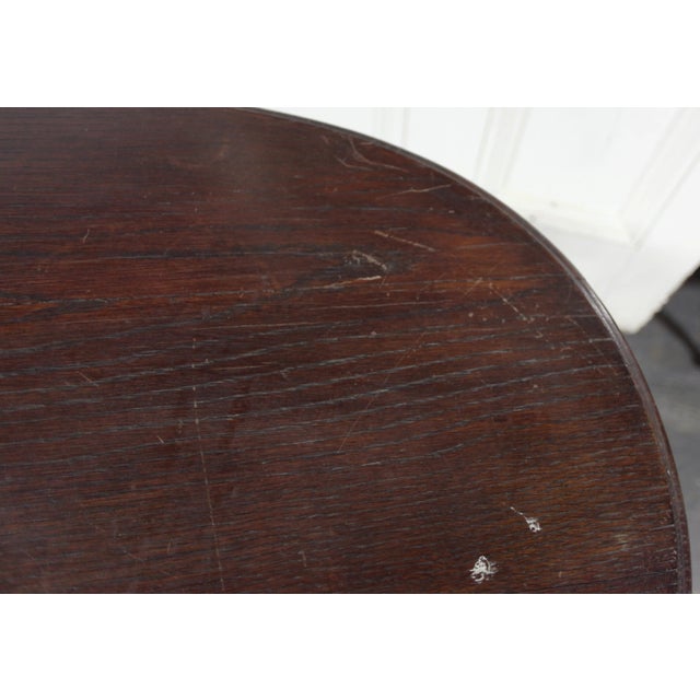 Antique early 20th century oval wooden table with carved apron.