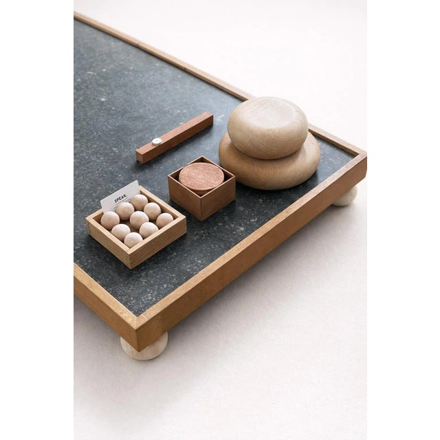 This coffee table boasts a minimalist yet elegant design. The dark granite top, subtly speckled, offers a smooth, robust,...