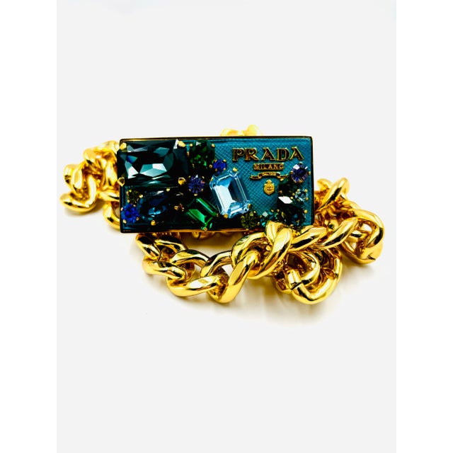 This rare early 2000s Prada belt features a splash of 80s Glam Rock! From the gold tone metal chunky chain to the buckle...