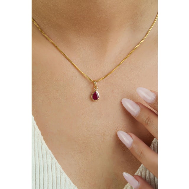This solitaire pendant showcases a 0.7 carat pear-cut ruby, set in 14k yellow gold. The ruby measuring 6.53 x 4.5 mm,...