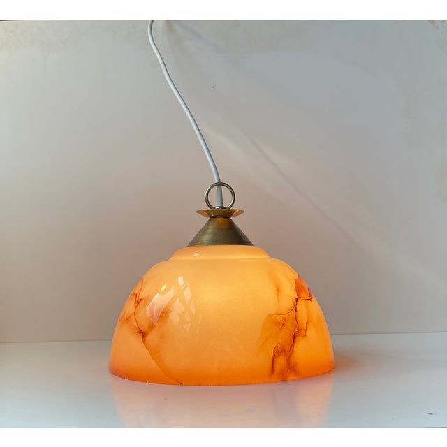 Elegant hanging pendant light composed of pastel-pink opaline glass shade decorated with maroon marble effects. It...