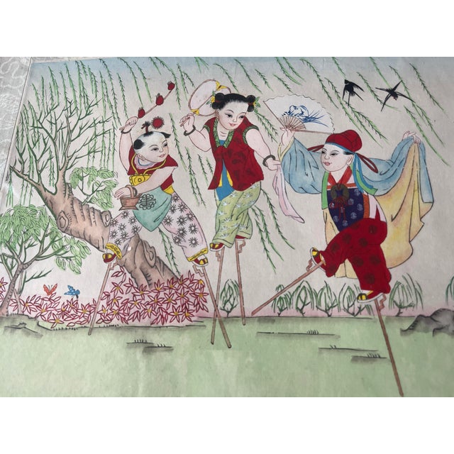 This antique oil painting on silk is depicting Chinese children at play, walking on stilts in a garden with butterflies,...