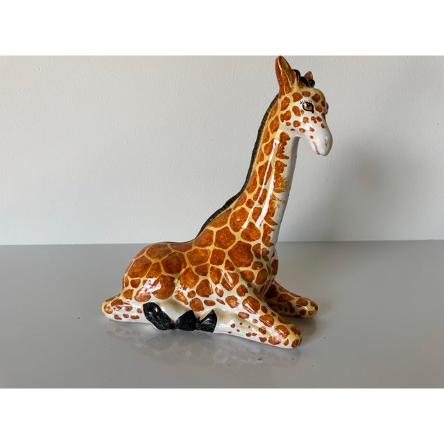 Charming vintage ceramic figurine of a seated giraffe, beautifully handcrafted and hand-painted with glossy glaze. The...