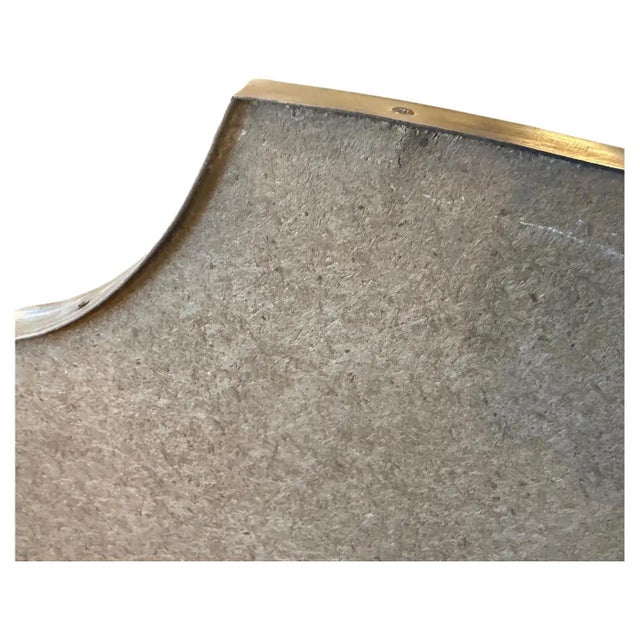 A shield shaped brass wall mirror designed and manufactured in Italy in the Sixties in the style of Giò Ponti, mirror is...