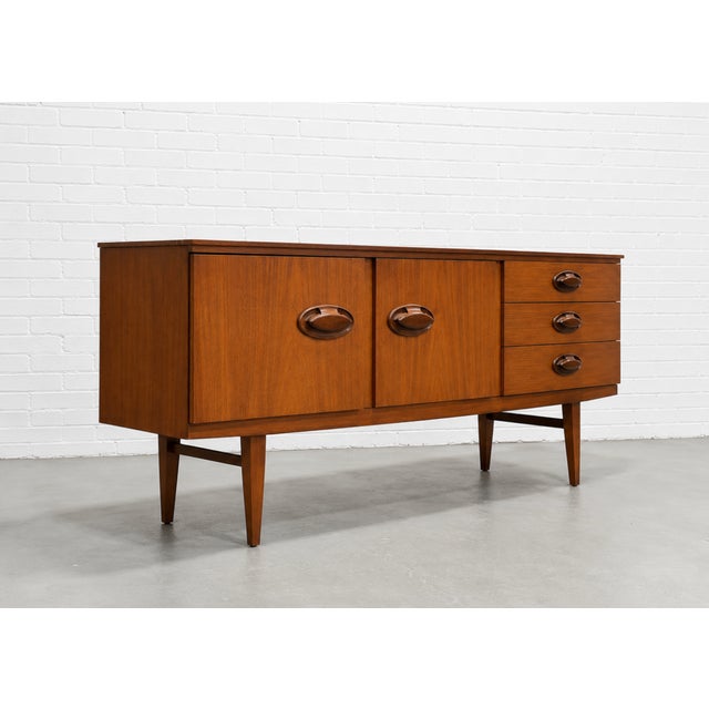 Mid Century Modern teak credenza by Beautility of England, featuring gorgeous warm teak wood grains, sculptural chunky...