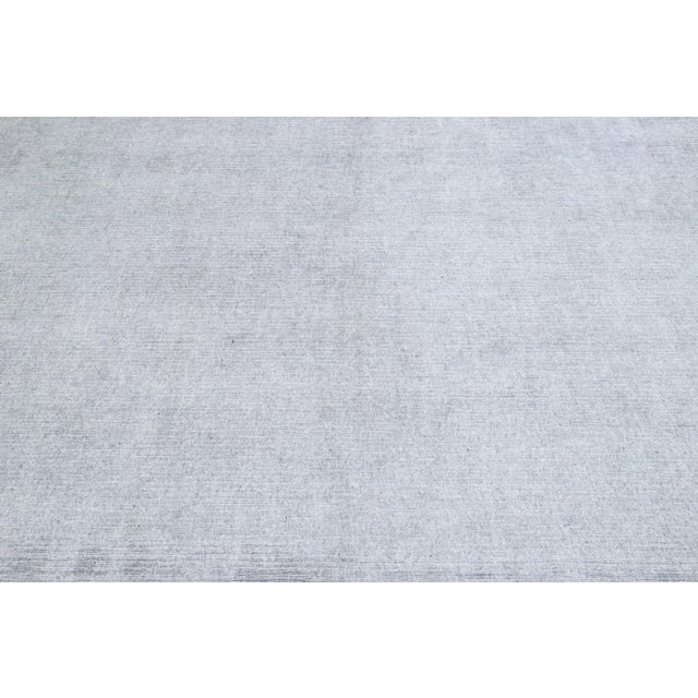 Meticulously crafted by hand using a blend of silk and wool, this exquisite contemporary rug showcases a stunning light...