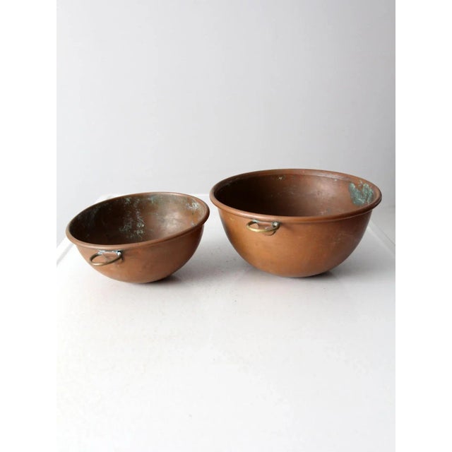 This is a pair of antique copper mixing bowls. The classic copper bowls have round bottoms for thorough mixing. They have...