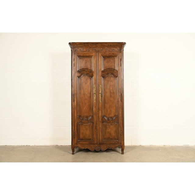 A gorgeous French Provincial Louis XV style armoire dresser or linen press By Baker Furniture USA, Circa 1980s Carved oak,...