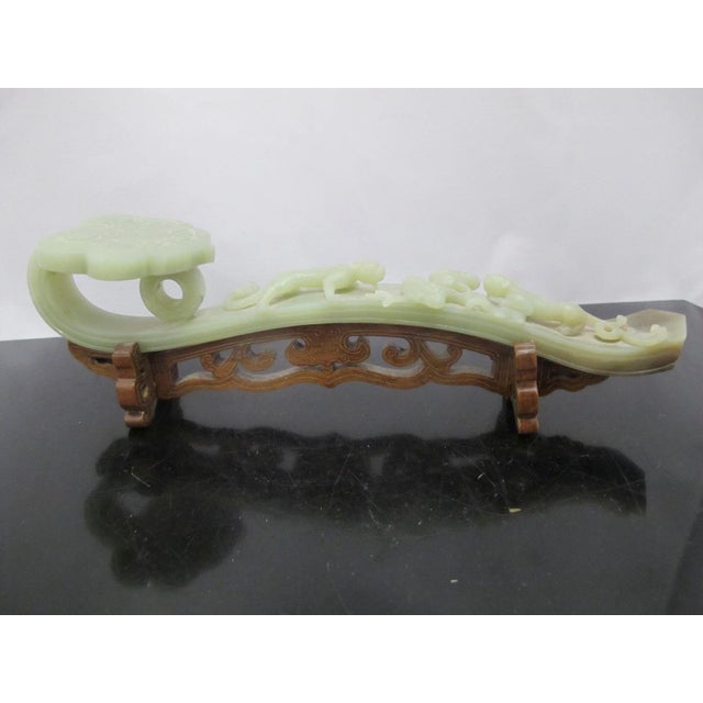 Carved Jade Ruyi scepter with custom stand. Carved jade with a greenish-grey color and some russet mottling. The scepter...