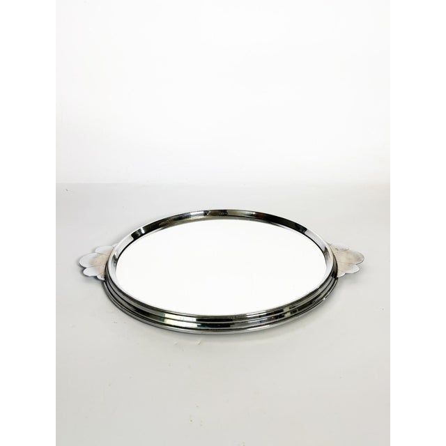 Round chrome-plated metal and mirrored tray, France, 1940s. An elegant circular serving tray composed of a chrome-plated...