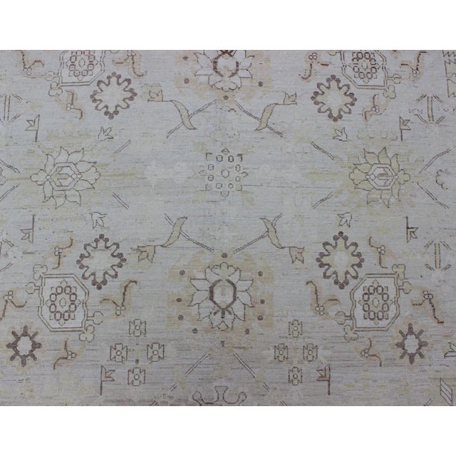 This Afghan made fine rug rug features a transitional design of stylized motifs in the central field, which are flanked by...