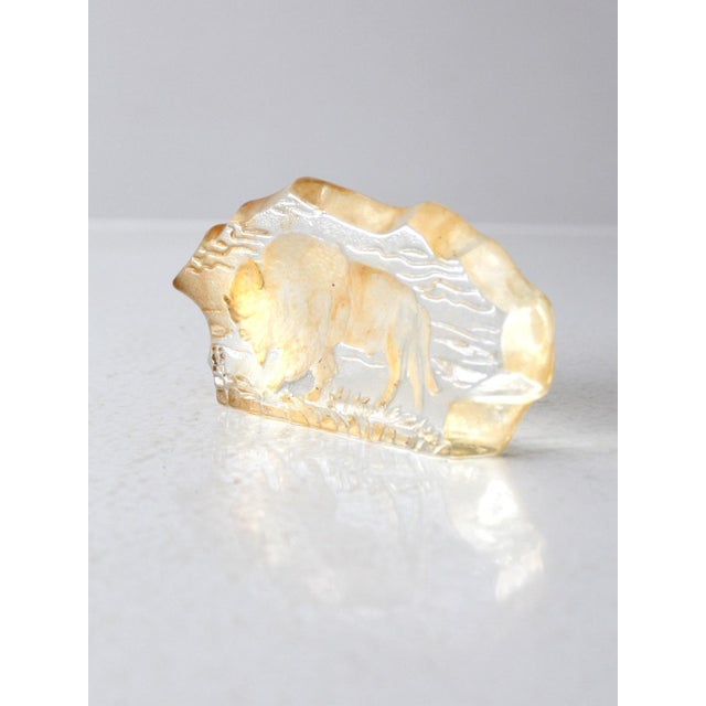 This vintage freeform resin paperweight features a serene scene of a grazing bison, beautifully preserved within clear...