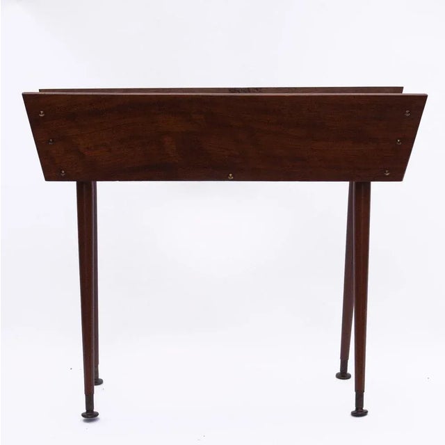 This vintage Jardiniere/Planter stands on four tapered cylindrical legs. This piece is attributed to the mentioned...