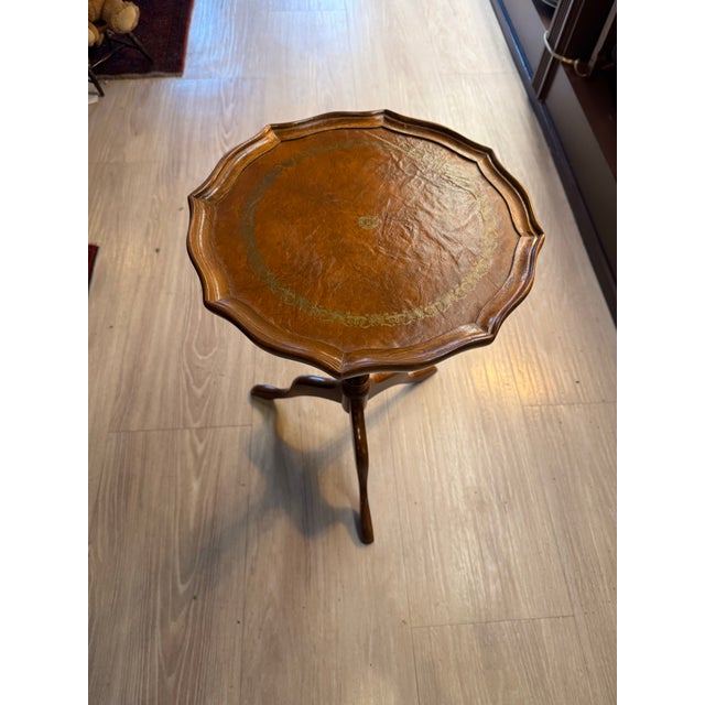 A classic Georgian-style pedestal table featuring a richly toned mahogany base and a finely tooled leather top with...