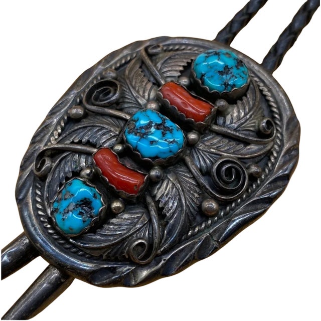 Striking vintage bolo tie featuring an ornate sterling silver slide set with three natural turquoise cabochons and two...