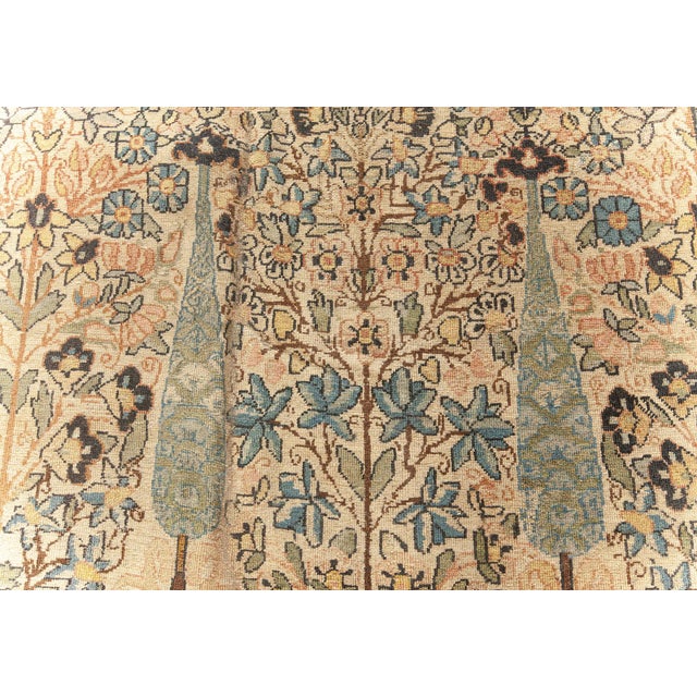 An early 20th century Persian Kirman (Kerman) antique rug, the sand field with an allover design in pastel tones of...