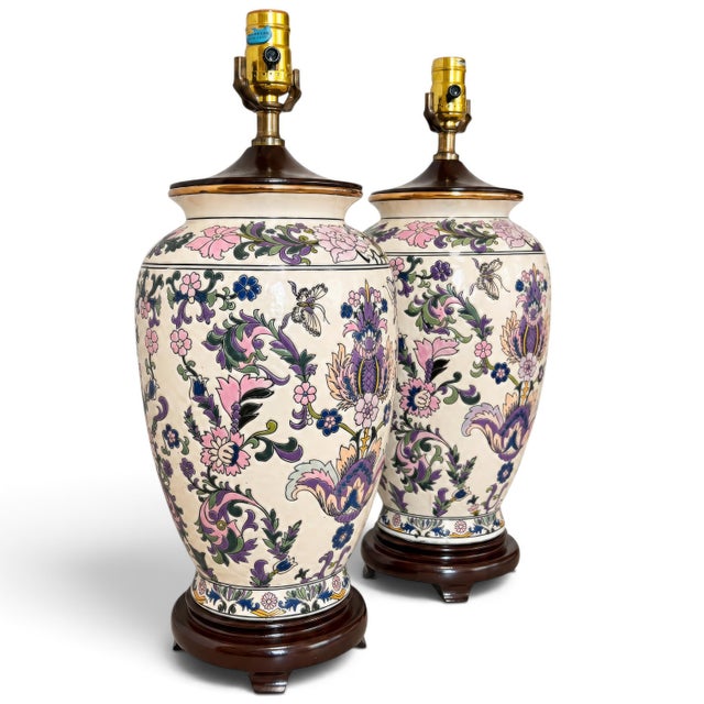A striking pair of vintage ceramic urn or ginger jar table lamps featuring an exuberant allover botanical and butterfly...