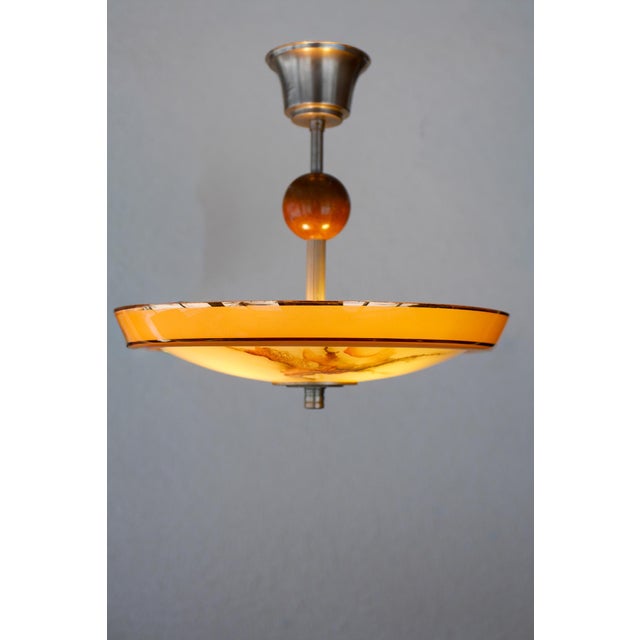 A striking Swedish Art Deco ceiling lamp, produced in the 1930s, exemplifying the elegance and bold material contrasts...