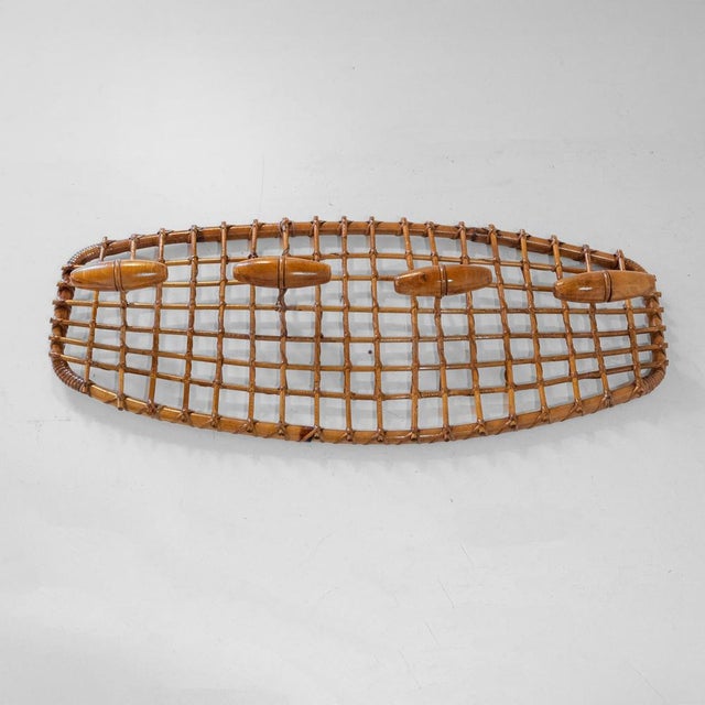 Elegant wall-mounted coat rack in bamboo and woven rattan manufactured in the 1960s (design attributed to Olaf von Bohr)....