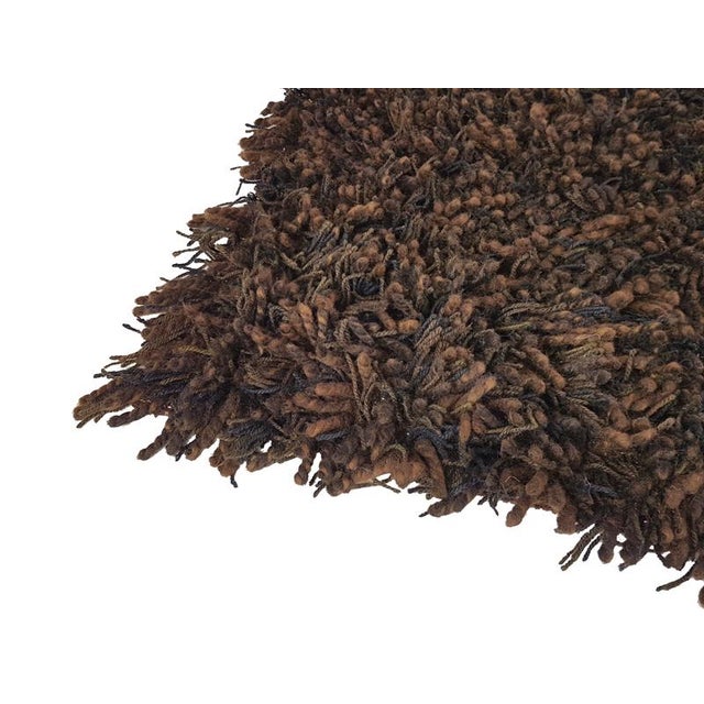 This Vintage rug was produced in Germany around the 1970s. It is made from 100% wool in several shades of brown. the rug...