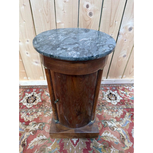 Empire period somno, first quarter of the 19th century, with a cylindrical wooden body featuring pronounced grain. The...