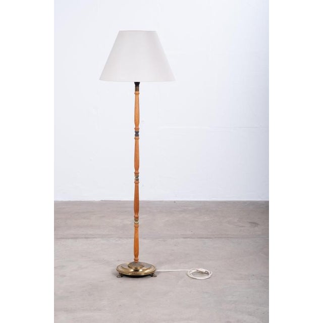 Elegant Danish floor lamp from the 1960s, combining warm teak with refined brass detailing. The original shade is...