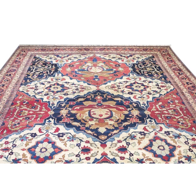 A boldly drawn, almost tribal-looking SE Persian city carpet in a large tile-scale pattern of ivory diamonds, and navy or...