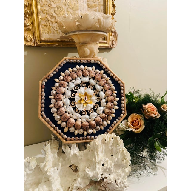 This is a handcrafted shell mosaic wall plaque, designed in a radial mandala pattern. Form & Structure • An octagonal...
