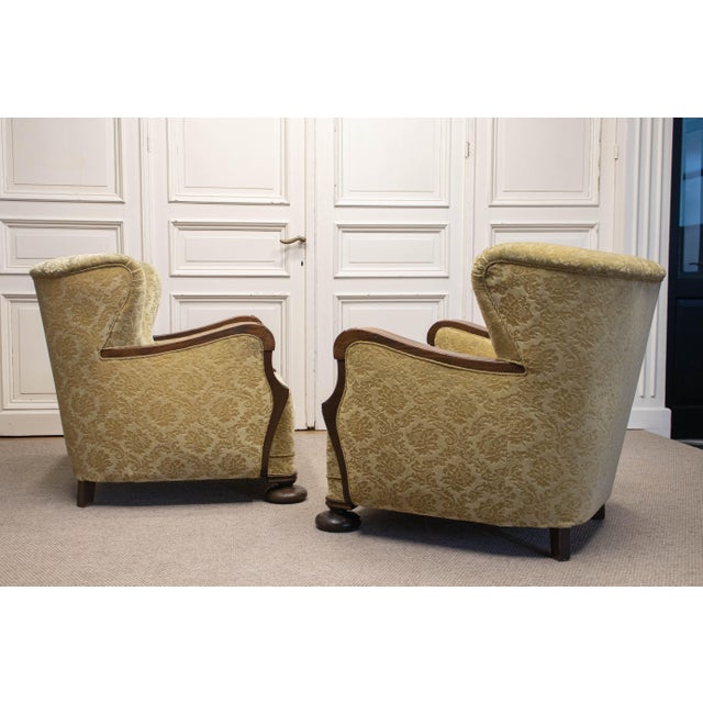 Pair elegant and characterful 1920s Art Nouveau wingback armchairs, beautifully combining sculptural oak detailing with...