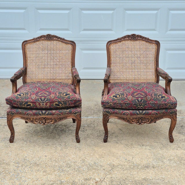 Louis XV Carved Walnut Cane Back Arm Chairs Fauteuils, A Pair Solid walnut frames with ornate high-relief carvings. Cane...
