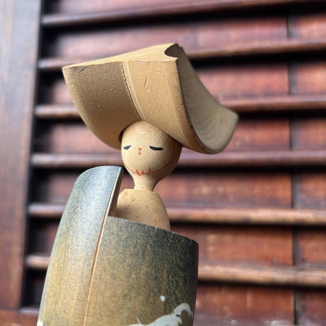 This Kokeshi depicts a Sado-Okesa dancer. The doll is hand-carved from wood and hand-painted. Dimensions: Height 21 cm,...