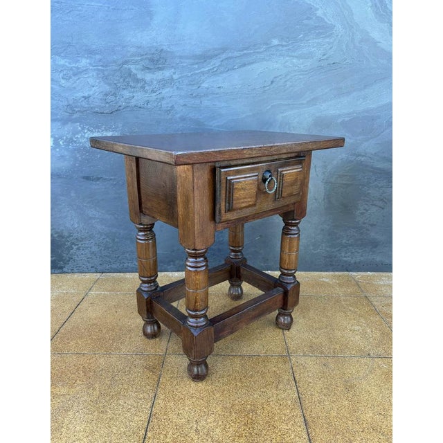 This Spanish side table dates from the early 20th century and is crafted in solid oak. The piece features a rectangular...