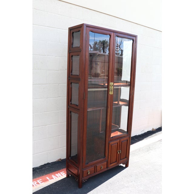 Elegant Asian-inspired rosewood curio display cabinet, beautifully crafted with clean architectural lines and warm wood...