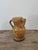 This handcrafted terracotta jug features a warm honey-yellow glaze with a rich patina. The rounded shape with a ringed...