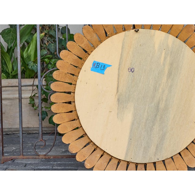French giltwood craftsmanship meets sculptural flair in this striking round mirror dating to the 1920s. The radial frame...