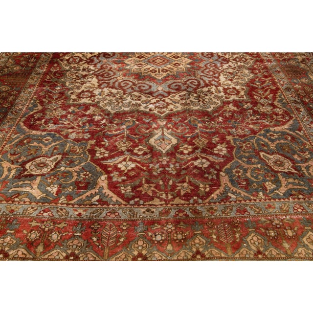 This Bakhtiari hand-knotted wool rug features a rust field and multicolor accents on a classic rosette design, crafted...