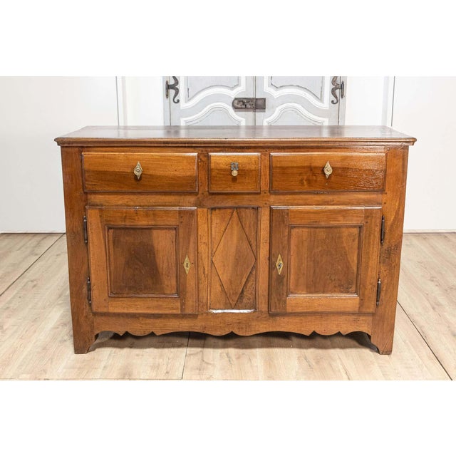 An Italian walnut buffet from the early 19th century, with three drawers over two doors, carved diamond motif and...