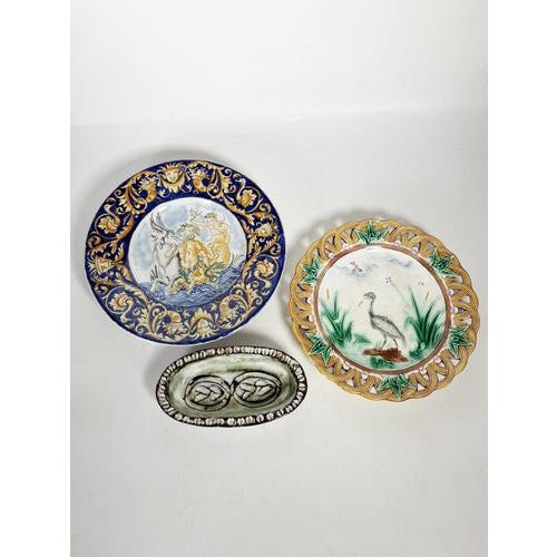 A decorative set comprising two early 20th-century majolica-style earthenware plates and a glazed terracotta platter. The...