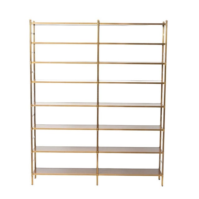 A monumental Regency style brass and mahogany etagere. The eight shelf etagere is both tall and wide, a stunning statement...