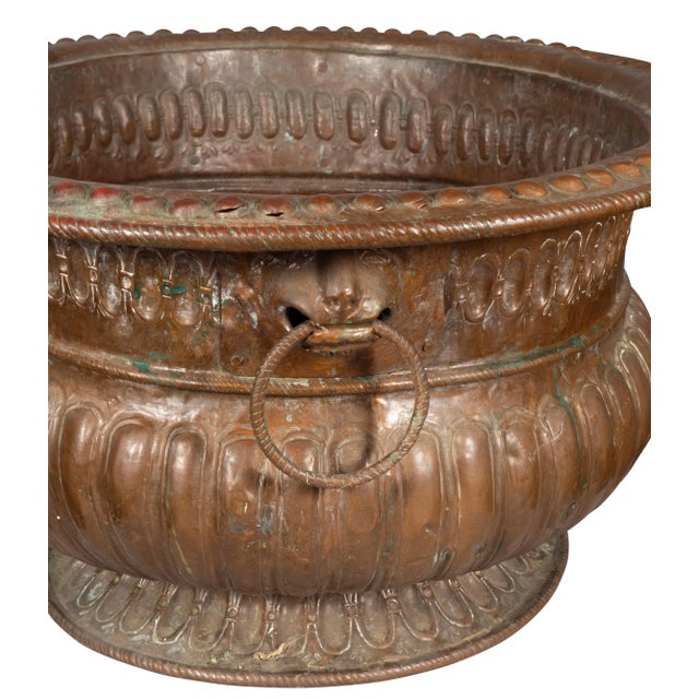 Oval with oxidized patination. Gadrooned body and animal head ring handles.