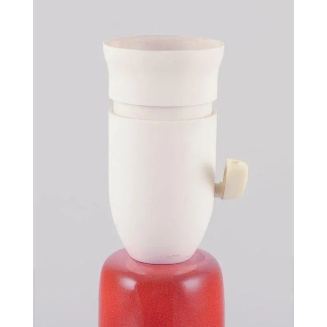 Frank Keramik, Denmark. Table lamp made of glazed stoneware. Minimalist retro design. Hand-glazed with orange glaze. Hard-...