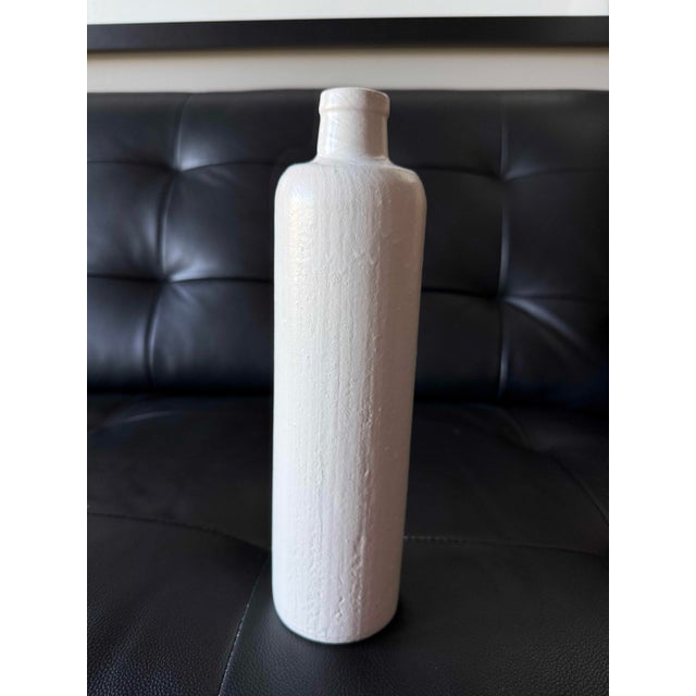 Elegant tall ceramic bottle with a simple, elongated silhouette and softly rounded shoulders. Finished in a warm matte...