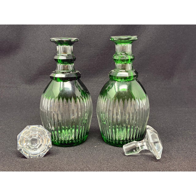 Emerald Green cut to clear, pair crystal decanters. Hand-blown and hand-cut. Ribbed cutting on sides. Starburst cut base....