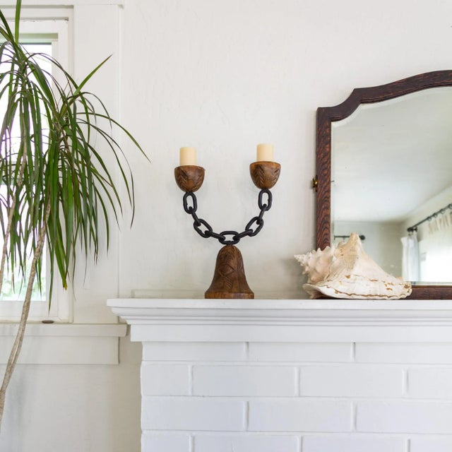 This unique candelabra features carved wood bowls to hold two thick, tapered candles, positioned at either end of a...