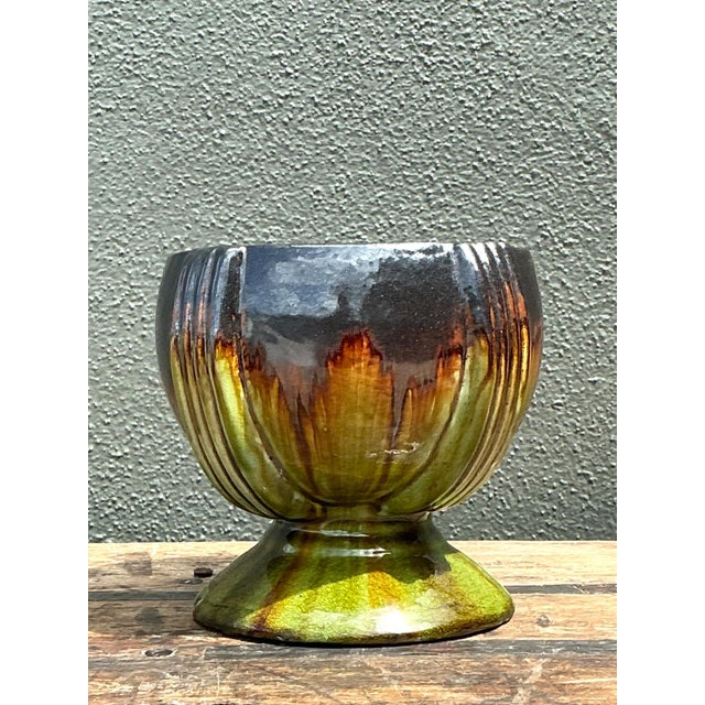 This vintage drip glaze ceramic pedestal bowl showcases a vibrant, glossy finish with a skillful application of glaze in...